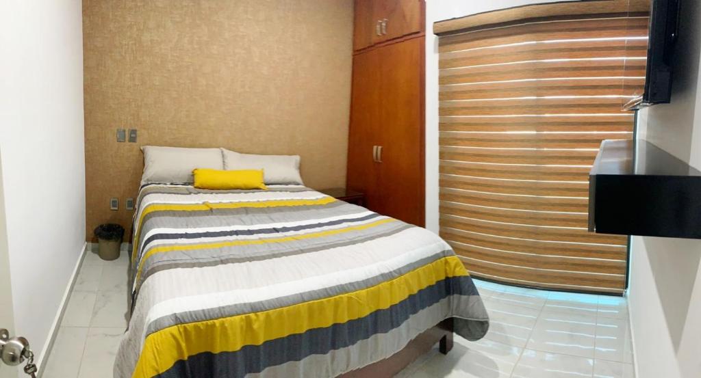 - une chambre avec un lit doté d'un oreiller jaune dans l'établissement Departamento Cardones - 5 Min Zona Dorada - 6 Personas Alberca Compartida, à Mazatlán