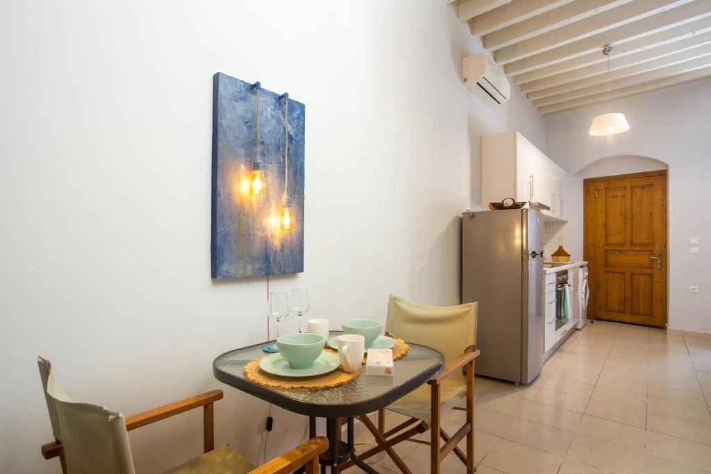 uma sala de jantar com uma mesa e um frigorífico em Art house old town in Ilha de Rhodes