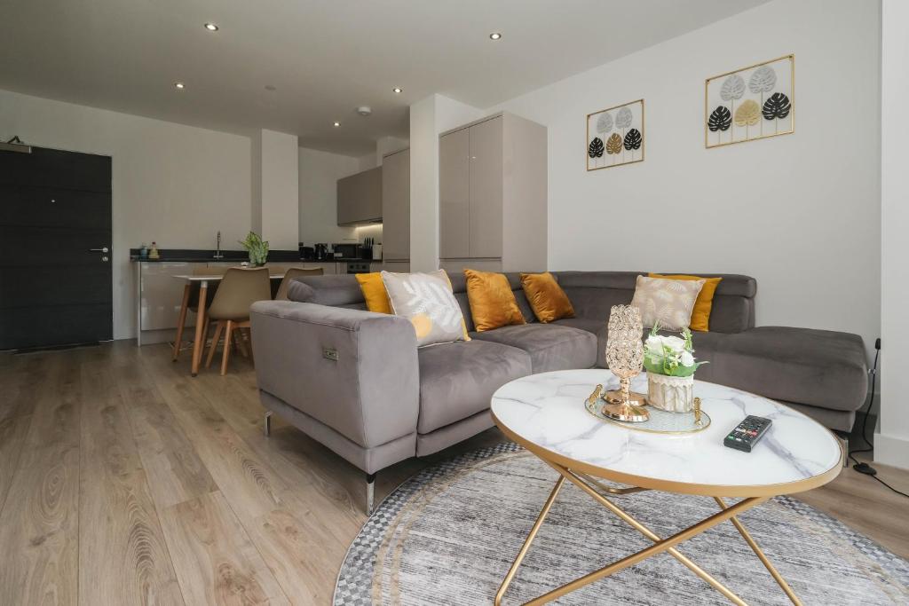 een woonkamer met een bank en een tafel bij Brand New 2 bedroom apartment Centre of Solihull in Solihull