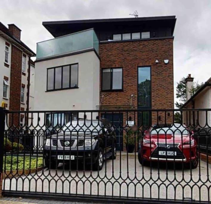 two cars parked in front of a house at ENTIRE PENTHOUSE WITH HUGE BALCONY in The Hyde