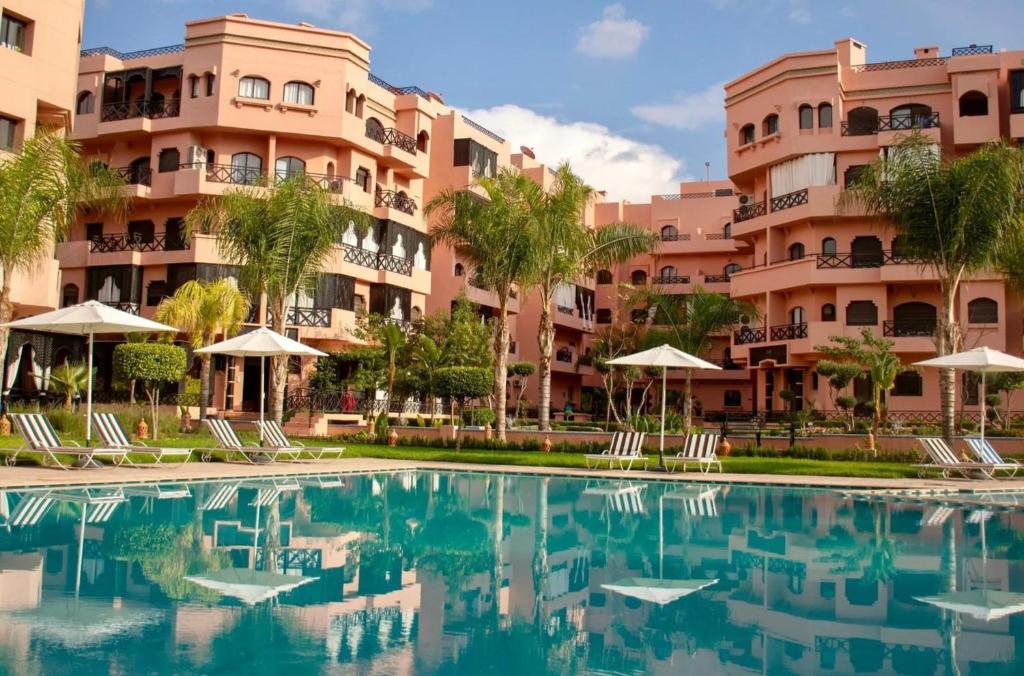 a swimming pool in front of a building at Appartement Premium Village, 5 piscines in Marrakesh