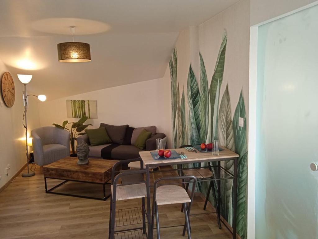 ein Wohnzimmer mit einem Tisch und einem Sofa in der Unterkunft Cosy et moderne centre ville Gourin in Gourin