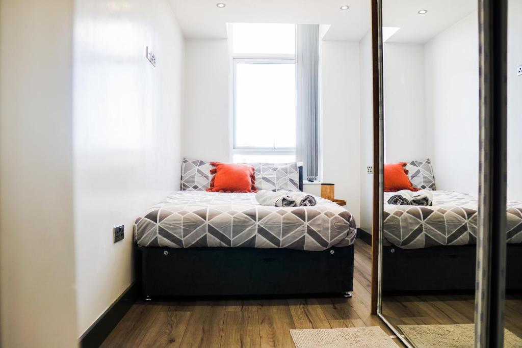 a bedroom with two beds and a mirror at Cozy Retreat in the Heart of Liverpool in Liverpool