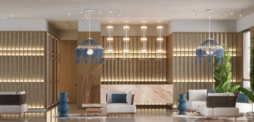 a lobby with chairs and chandeliers at Volmar Hotel in Durrës