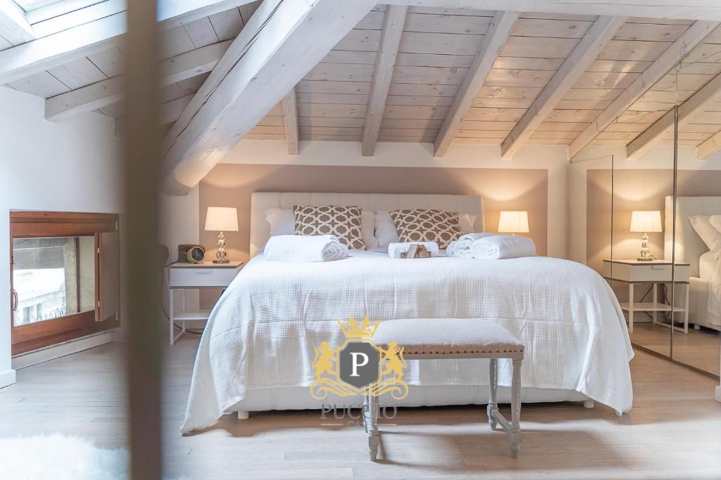 ein Schlafzimmer mit einem großen Bett mit einer weißen Tagesdecke in der Unterkunft Arena Balcony in Verona