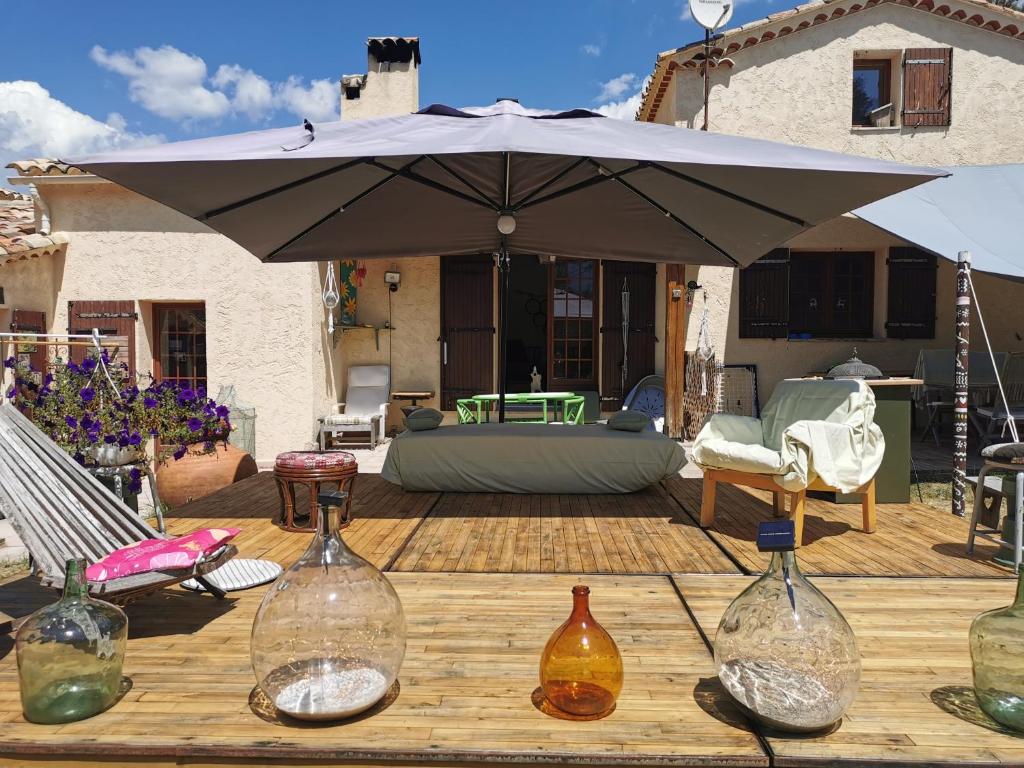 parasol na drewnianym stole z butelkami w obiekcie Clos de l'Artuby w mieście Valderoure