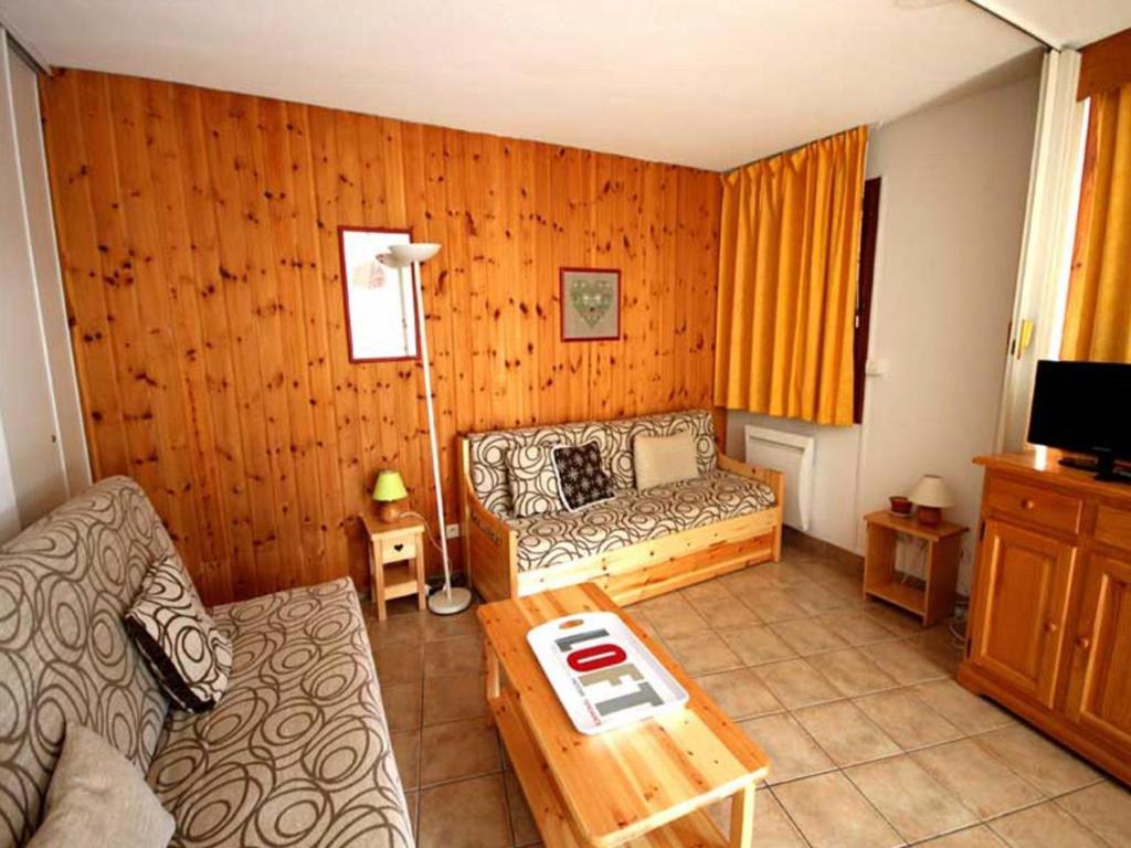 ein Wohnzimmer mit einem Sofa und einem Tisch in der Unterkunft Appartement Avec Balcon in Vars
