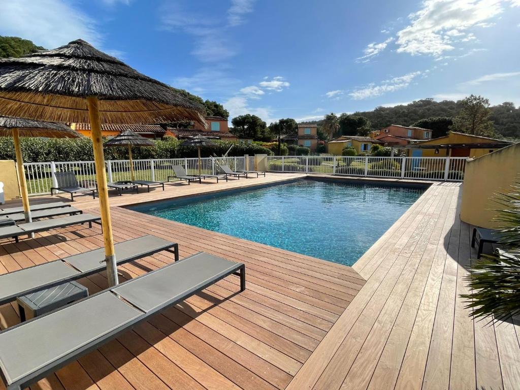 - une piscine avec des chaises, un parasol et une terrasse dans l'établissement CASA PALOMBAGGIA - Piscine Chauffée, à Porto-Vecchio