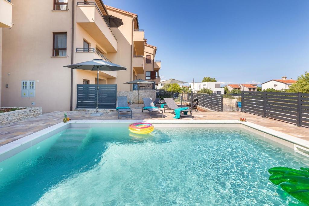 een zwembad met een frisbee in het water bij Apartments Bluemare with Shared Pool in Ližnjan