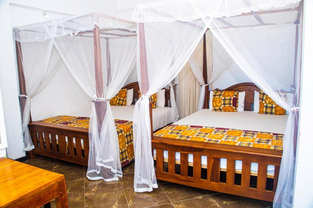 2 camas en una habitación con mosquiteras en Hotel Sanasuma en Hambantota