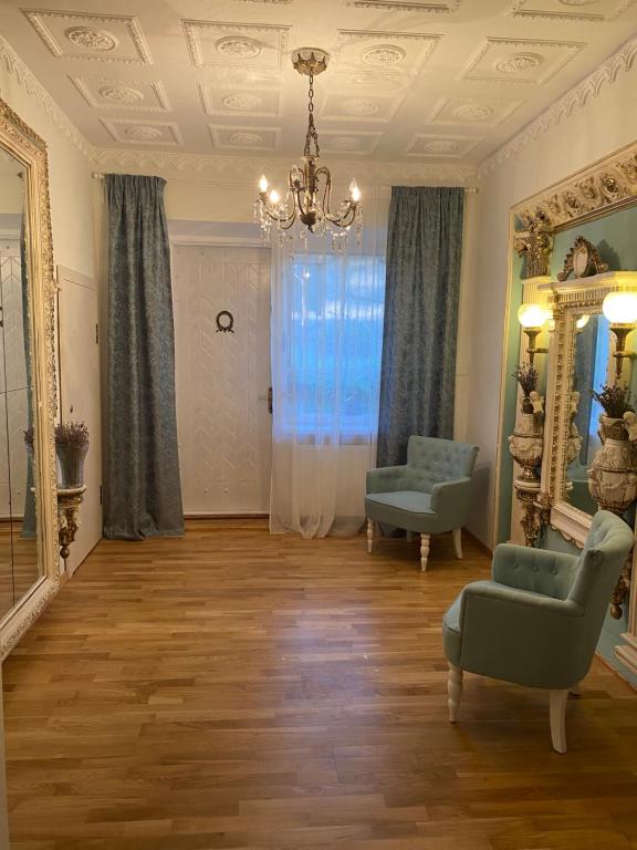 a living room with a chair and a mirror at Petro Apartamentai in Kačerginė