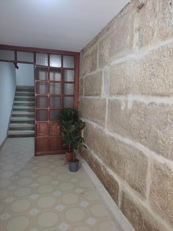 a brick wall with a door and a potted plant at Celia in Redondela