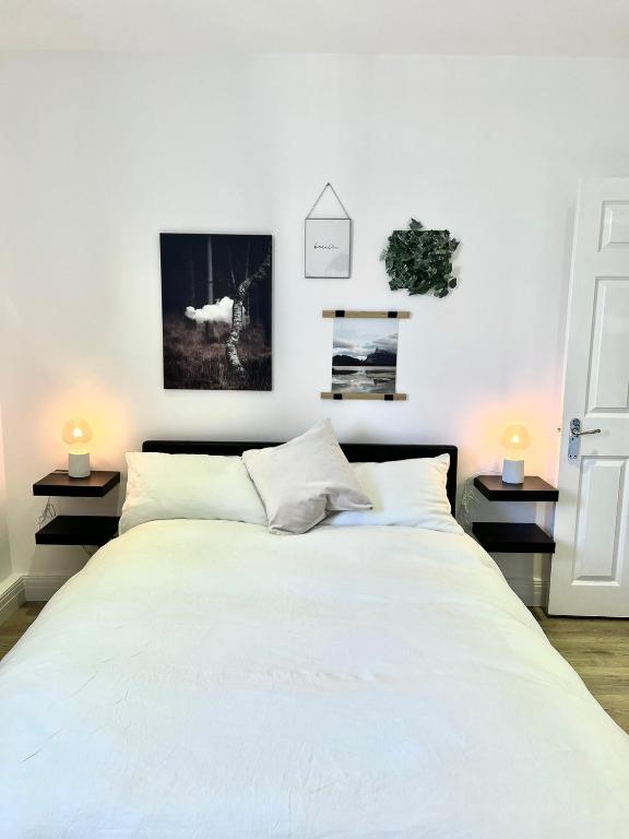 1 dormitorio con 1 cama blanca grande y 2 lámparas en Bright & Spacious 1 bed steps from Hyde Park, en Londres