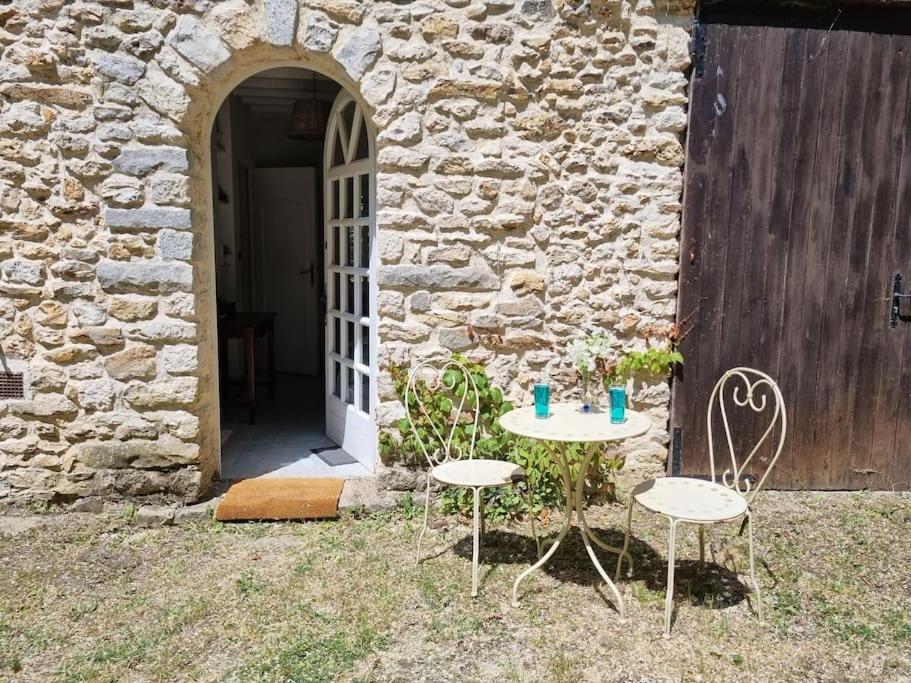 a table and two chairs in front of a building at La Parenthèse Campagnarde in Richarville