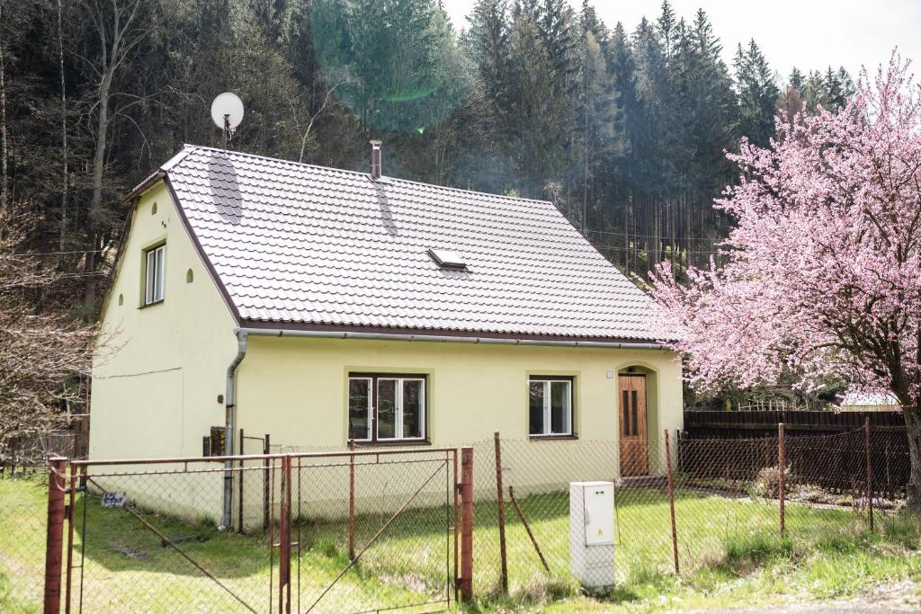 a white house with a fence in front of it at Chalupa pod vysokou in Ludvíkov