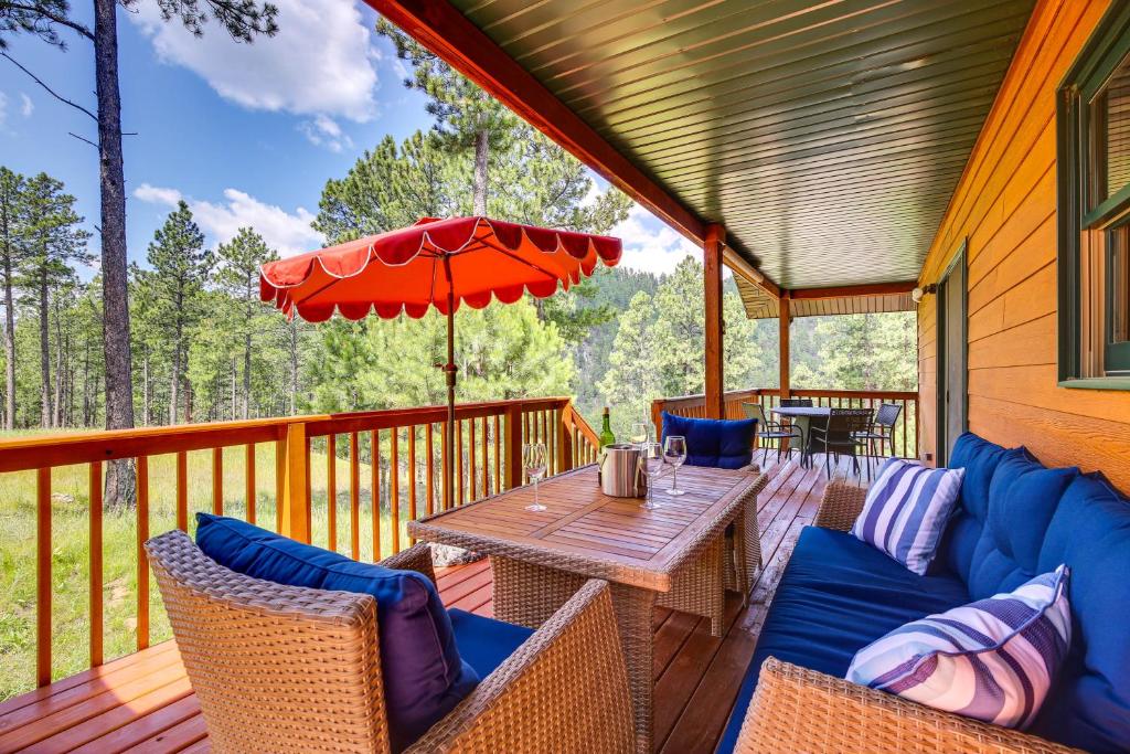 a deck with a table and chairs and an umbrella at Keystone Escape w/ Amazing Mt Rushmore View! in Keystone