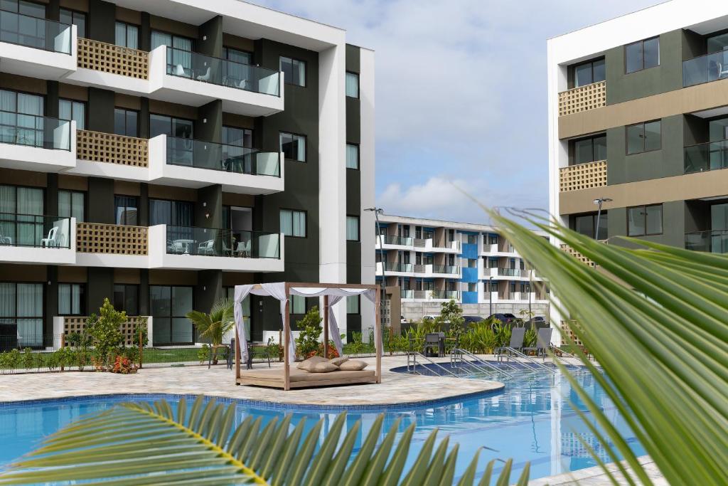 a view of a hotel with a pool and a building at Praia de Muro Alto Mana Beach 003 C in Porto De Galinhas