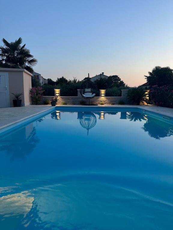 een groot zwembad met blauw water bij Holiday House Serenity in Malinska