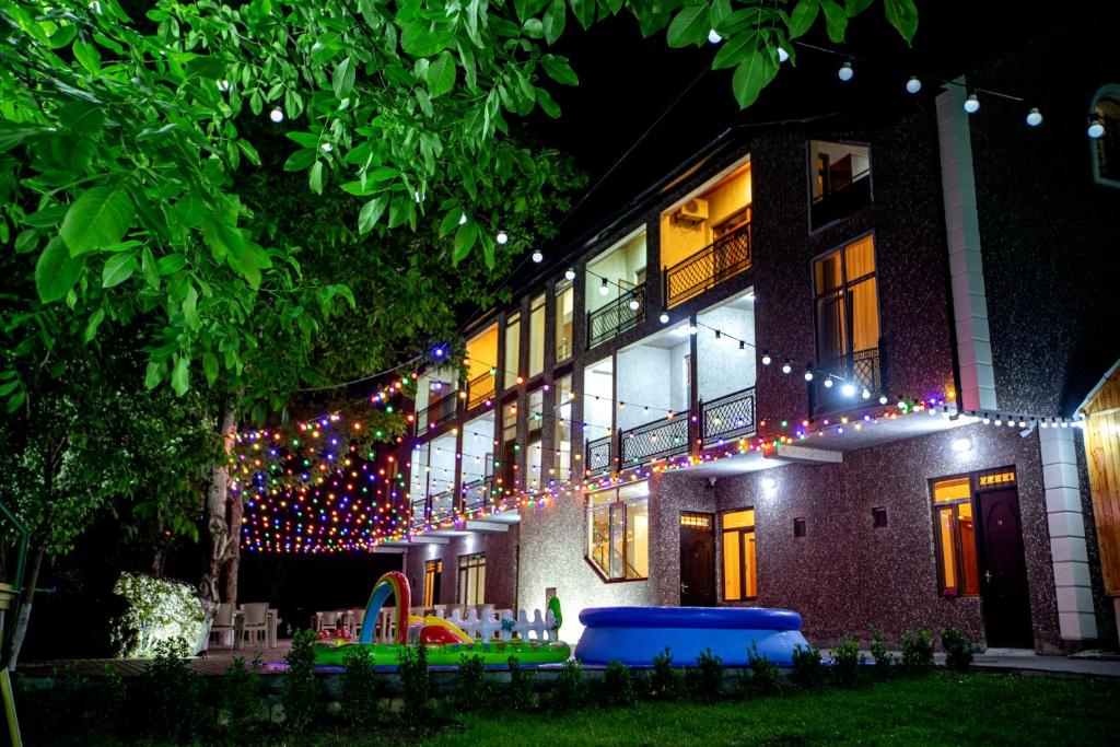 a house with christmas lights on the side of it at Family Inn in İsmayıllı