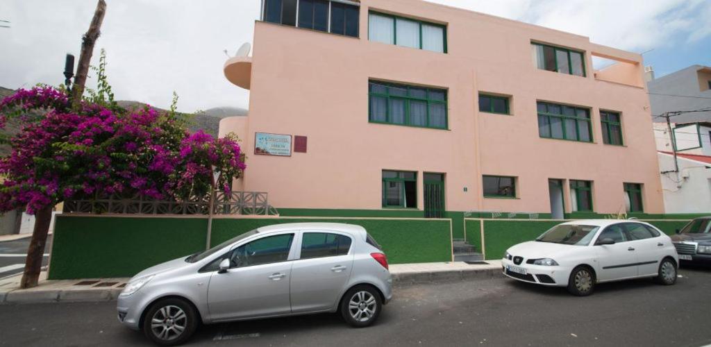 due auto parcheggiate in un parcheggio di fronte a un edificio di Apartamento Bajo en el Tamaduste Zona Privilegiada a Tamaduste