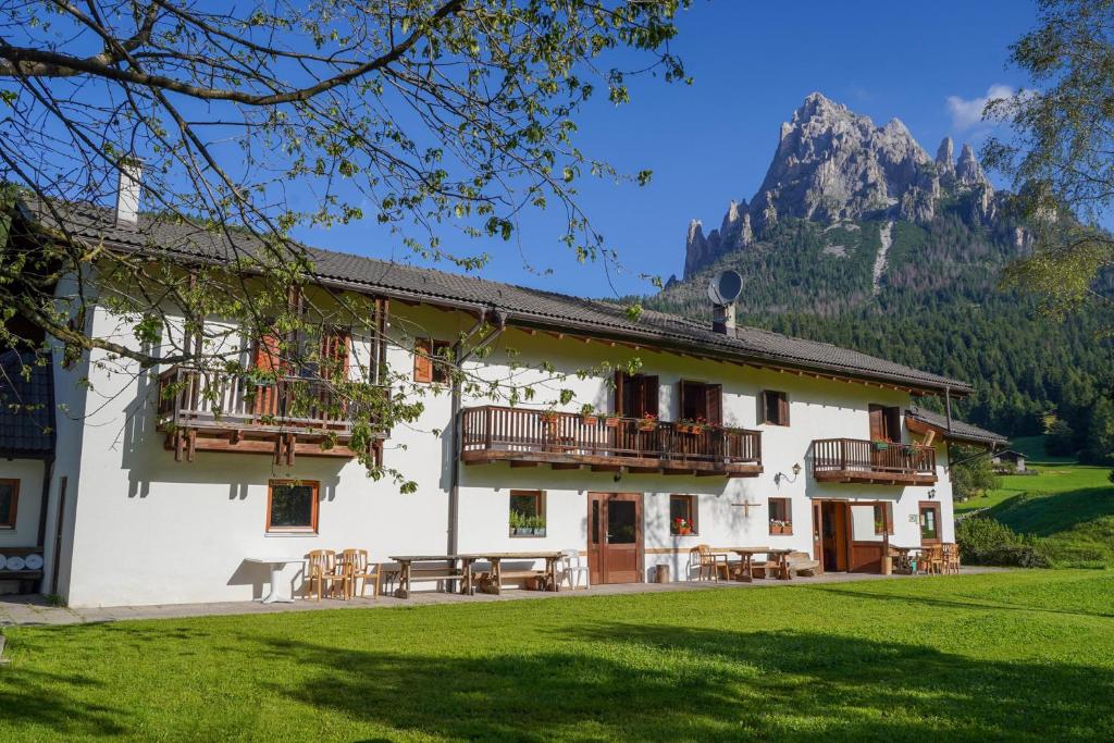 a white building with wooden balconies and a mountain at Locanda Val Canali in Siror