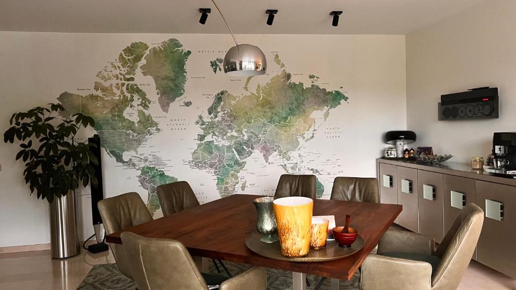 una mesa de comedor con un mapa mundial en la pared en Ikigai, en Oud-Turnhout