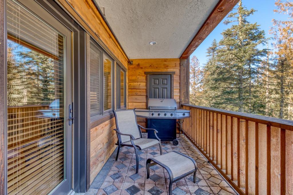 a porch with two chairs and a grill on it at #203 Grand Lodge South in Government Camp