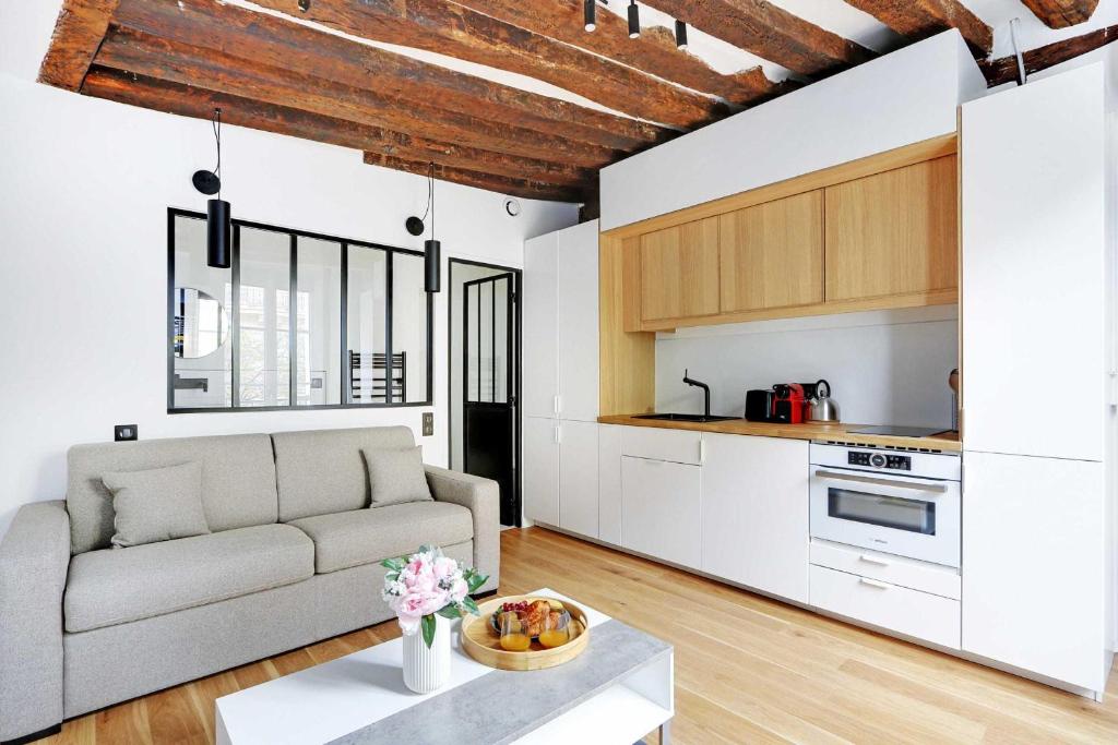 a living room with a couch and a table at Studio 2P rénové rue des Archives Marais Clim 3 in Paris