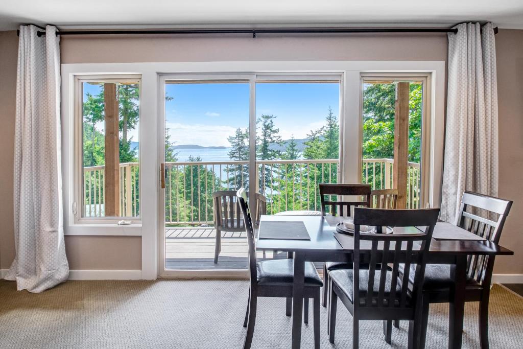 een eetkamer met een tafel en stoelen en een groot raam bij Cascade Bay Getaway in Eastsound