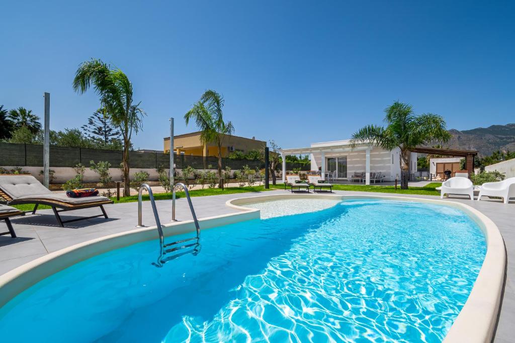 a swimming pool with blue water in a yard at Villa DellaTerra in Alcamo