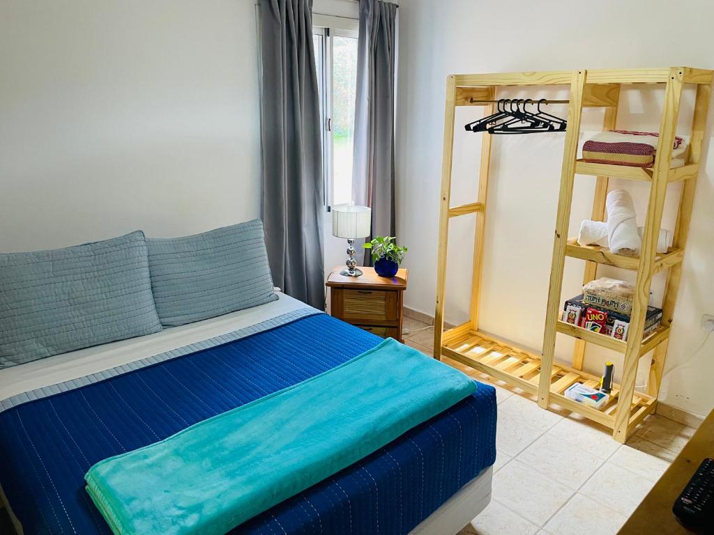 Un dormitorio con una cama azul y una escalera en Preludio en Villa General Belgrano