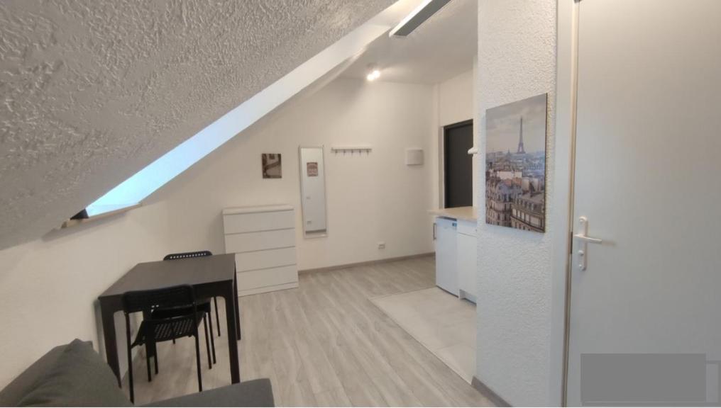 een witte kamer met een bureau en een piano bij Miko apartamentai in Kaunas