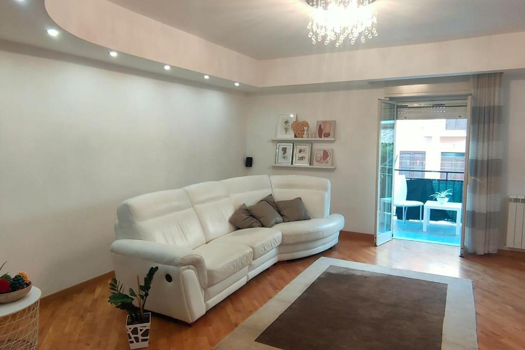 un soggiorno con divano bianco e lampadario pendente di Elegant house a Pietraperzia
