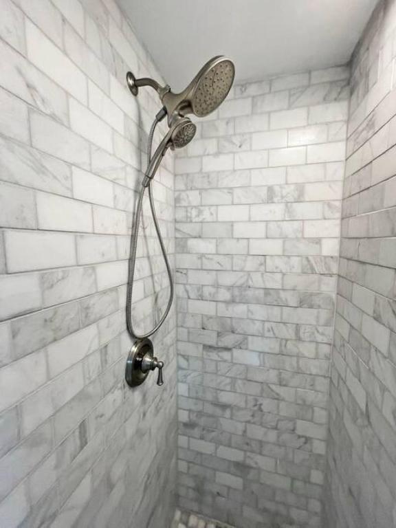 a shower with a shower head on a brick wall at Cute Microapartment Walkable to Everything in Cincinnati