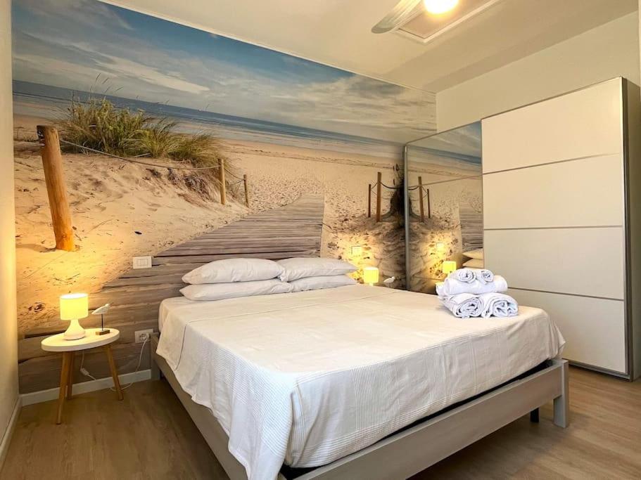 a bedroom with a bed with a painting of a beach at Apt. MarisDomus, 300m dal Centro in Pula