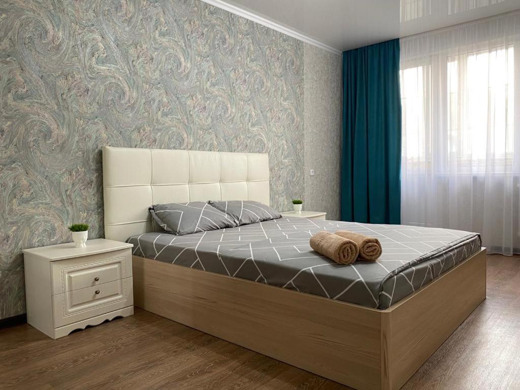 ein Schlafzimmer mit einem großen Bett und einem Fenster in der Unterkunft 1 ком квартира в районе City center in Oral