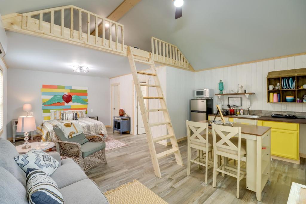 a living room with a loft bed and a kitchen at Cozy Studio Cabin about 1 Mi to Greers Ferry Lake! in Fairfield Bay