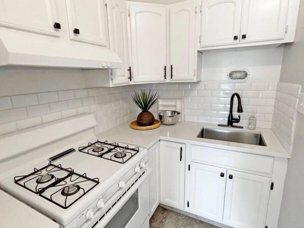 a white kitchen with a stove and a sink at Lovely 2bd in Mount Adams near Downtown and OTR in Cincinnati