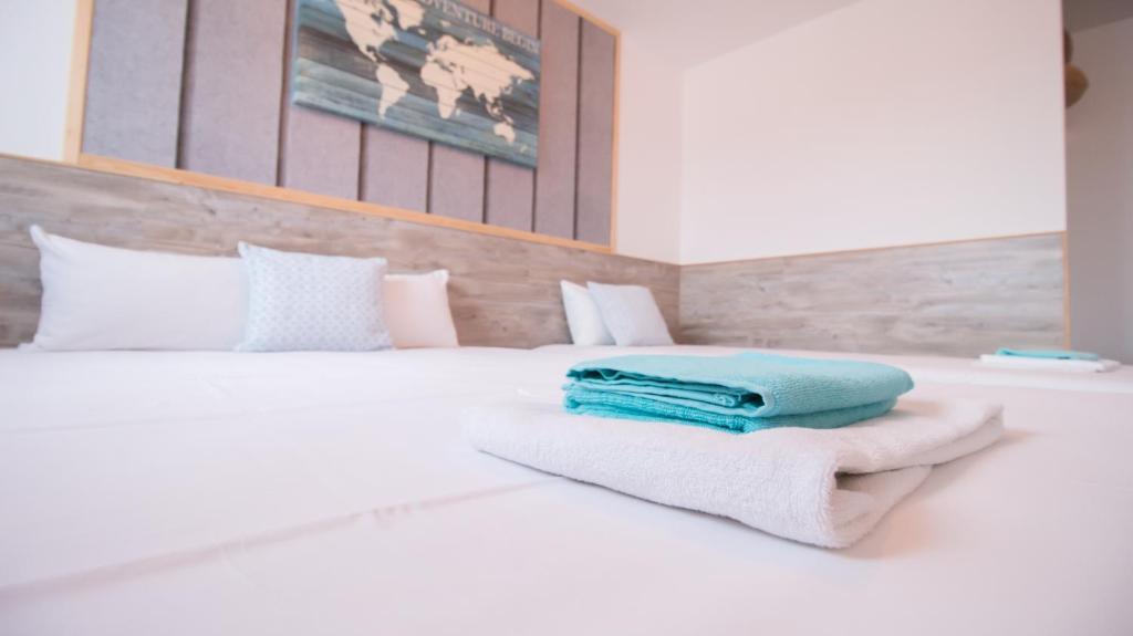 a white bed with towels on top of it at APPARTEL 76 CHAMBRES in Rouxmesnil-Bouteilles