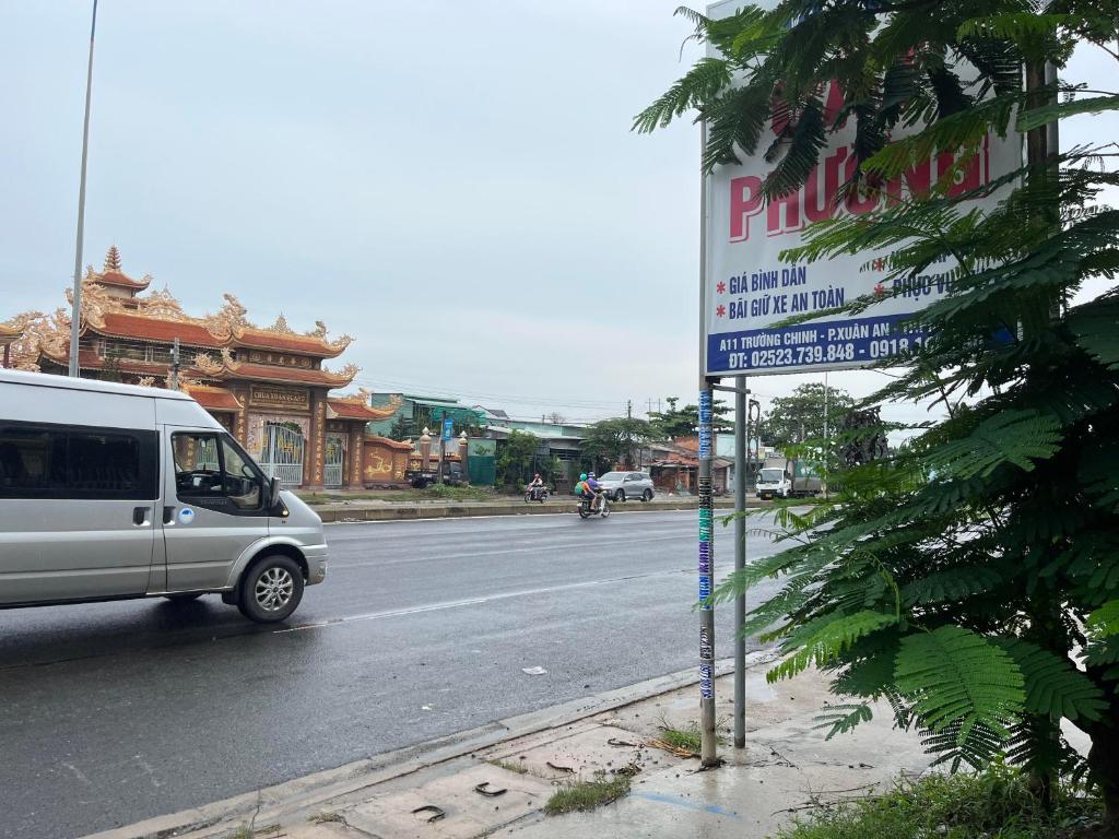 a white van driving down a street with a sign at Cát Phượng Motel in Phan Thiet