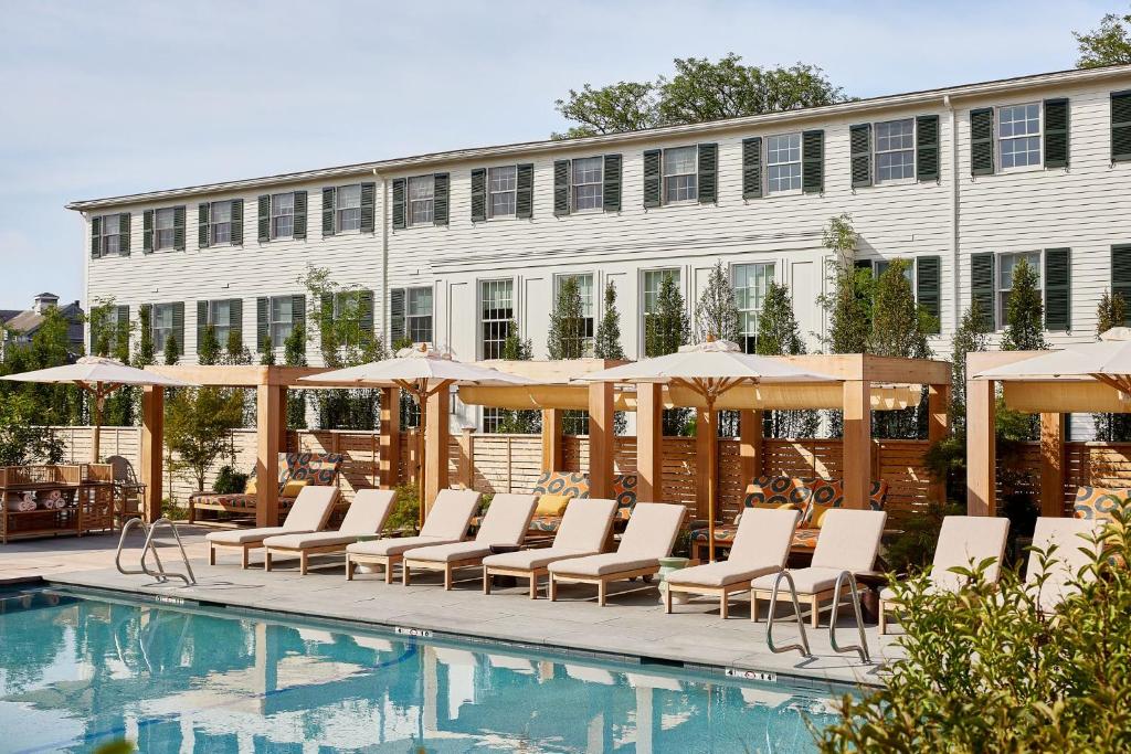 a pool with chairs and umbrellas next to a building at Faraway Martha's Vineyard in Edgartown