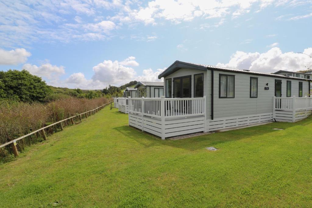 a row of cottages on a grass field at St Mawgan's Cove 1 in Newquay