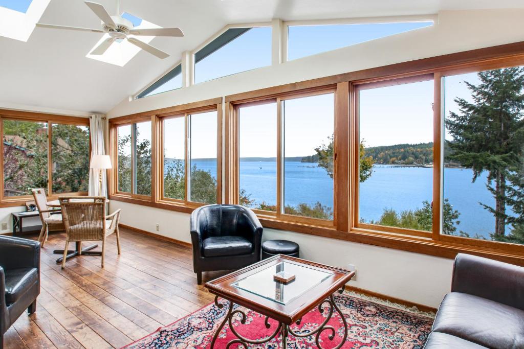 a living room with windows and a view of the water at Seabeck House & Cottage on Hood Canal in Seabeck