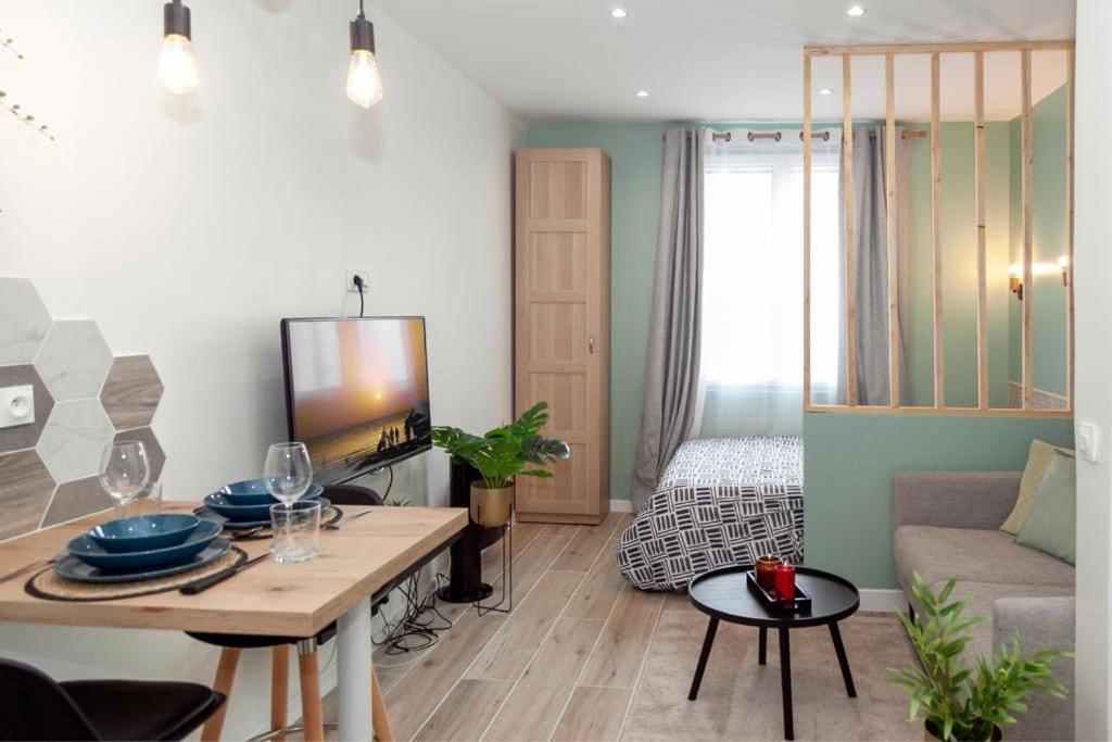 een woonkamer met een tafel en een bank bij Studio cozy, proche paris in Pré Saint Gervais
