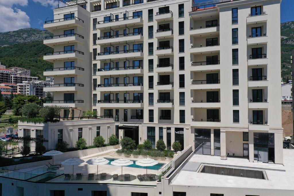 an apartment building with a balcony with a pool at CASA AL MARE RESIDENCE in Bečići