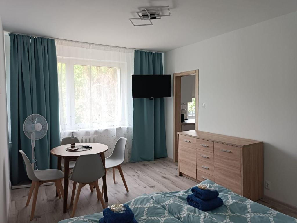 1 dormitorio con cama, mesa, mesa y sillas en Mewa86 en Gdynia