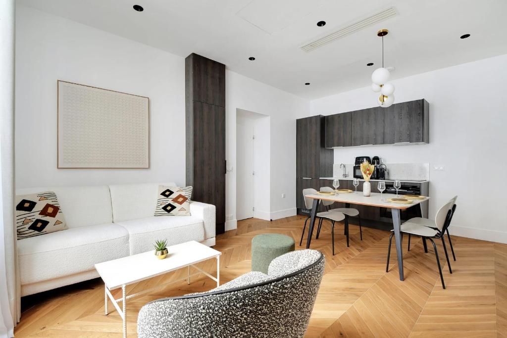 un salon avec un canapé blanc et une table dans l'établissement Moderne appartement - 1BR 4P - Opéra, à Paris