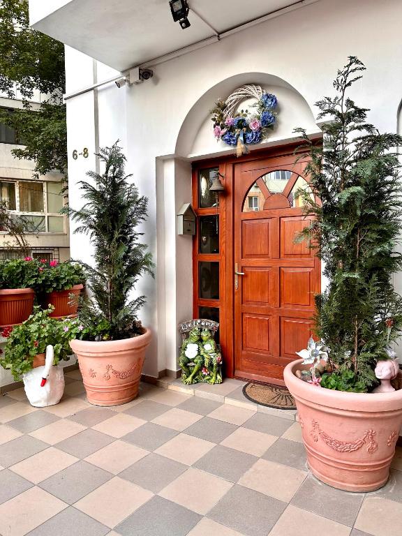 a front door of a building with potted plants at Budapest Residence in Bucharest
