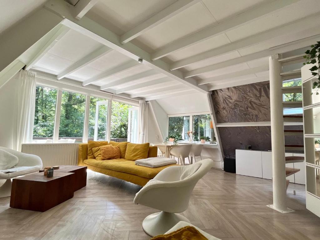 a living room with a yellow couch and a table at Vakantiewoning Sunclass Durbuy Ardennen huisnummer 68 in Durbuy