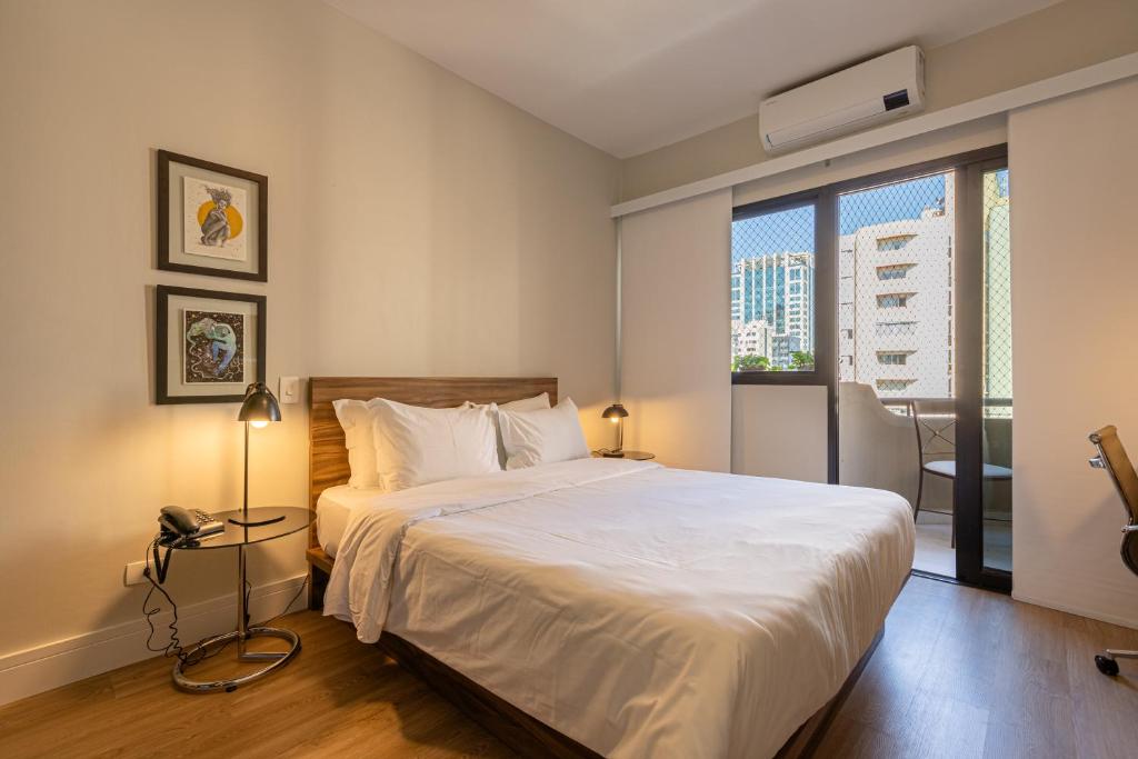 a bedroom with a large white bed and a window at BGV - Le Bougainville By Anora Spaces in Barueri